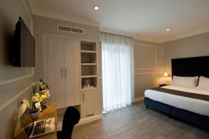 a bedroom with a bed and a dresser at Seven Suites in Rome