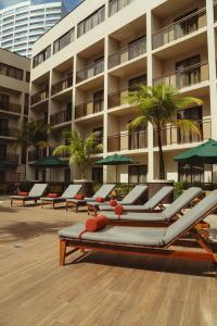 a row of lounge chairs in front of a building at Afago Mareiro Hotel in Fortaleza
