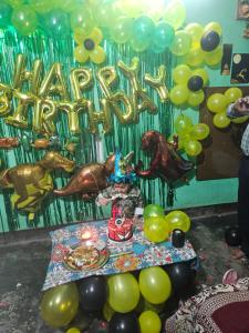 a party with a table with balloons and a sign that reads happy birthday at Royal Rudraksh Palace in Bābatpur