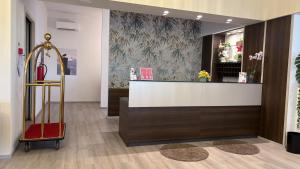 a store lobby with a checkout counter with a red suitcase at Hotel Bel Sito Peschiera in Peschiera del Garda