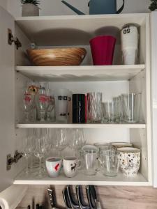 a cupboard filled with lots of glasses and bowls at Horizon Hill in Cserszegtomaj