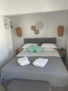 a bedroom with a large bed with green and white pillows at CHORA NEST KYTHNOS in Kithnos