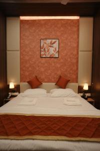 a bedroom with a large white bed with red walls at Gamagashree Hotel and Fine Dine in Sāgar