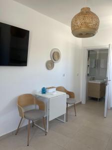 a room with a table and two chairs and a tv at CHORA NEST KYTHNOS in Kithnos