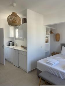 a white kitchen with a bed in a room at CHORA NEST KYTHNOS in Kithnos
