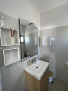 a white bathroom with a sink and a mirror at CHORA NEST KYTHNOS in Kithnos