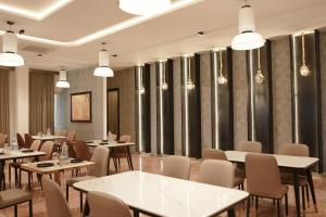 a dining room with tables and chairs and lights at Gamagashree Hotel and Fine Dine in Sāgar
