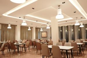 a dining room with tables and chairs and lights at Gamagashree Hotel and Fine Dine in Sāgar