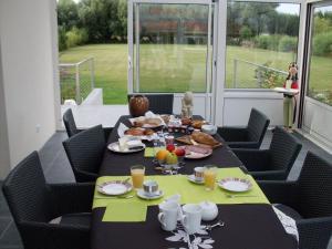 a dining room table with food and drinks on it at Le Pic-Vert in Rang-du-Fliers