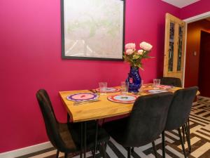 a dining room with a table with a vase of flowers at Lindean in Ballater