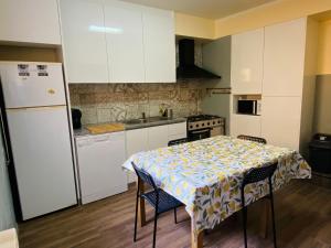 a kitchen with a table and a white refrigerator at SwordFish Eco-House Peniche in Peniche