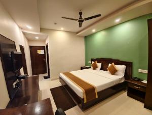 a bedroom with a bed and a green wall at RAILVIEW HOTEL- Nr Platform-1, Railway Station in Bhubaneshwar