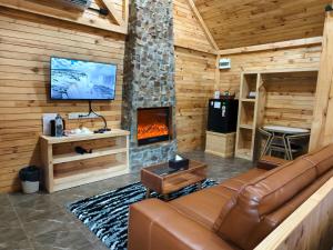 a living room with a couch and a fireplace at Khaoyai Art Tree in Pong Talong
