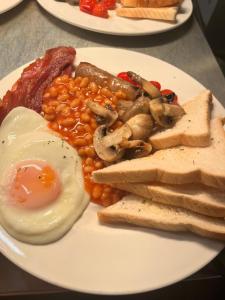 a plate of food with eggs bacon beans and mushrooms at The Lincoln Arms Pub & Rooms in Dorking