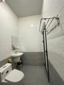 a white bathroom with a toilet and a sink at La Maison DaLat Home in Ấp Kim Thạch