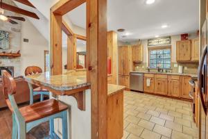 a large kitchen with wooden cabinets and a table at The Cabin at Rooster Ridge in Fischer