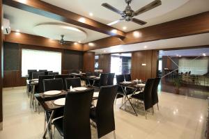 a restaurant with black chairs and tables and a ceiling at RAILVIEW HOTEL- Nr Platform-1, Railway Station in Bhubaneshwar