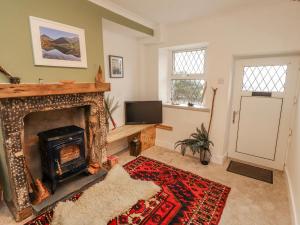 a living room with a fireplace and a tv at 25 Low Seaton in Workington