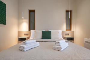 a bedroom with a bed with towels on it at Myrina Concept in Myrina