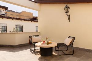 a patio with two chairs and a table and a lamp at Bob W Rome San Lorenzo in Rome