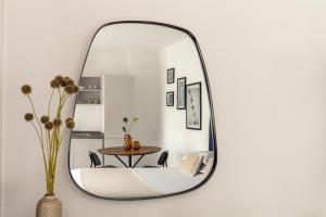 a mirror hanging on a wall with a table and chairs at Bob W Rome San Lorenzo in Rome +30 photos