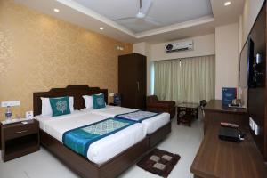 a bedroom with a bed and a desk and a television at RAILVIEW HOTEL- Nr Platform-1, Railway Station in Bhubaneshwar