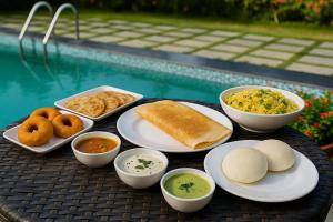 a tray of food on a table next to a pool at The K11 Golden Gate in Chennai