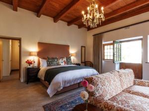 a bedroom with a large bed and a chandelier at Navarre Residence in Stellenbosch