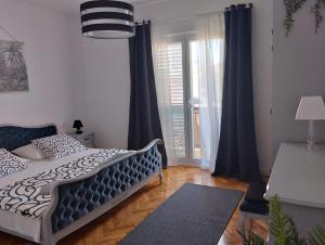 a bedroom with a bed and a large window at Keti House Rooms in Vela Luka