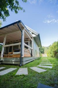 a house with a screened in porch on the grass at Krukówka Białogóra & jacuzzi in Białogóra
