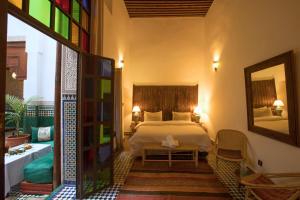 a bedroom with a bed and a mirror at Riad Ruh Fes in Fez
