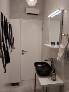 a bathroom with a black sink and a mirror at Keti House Rooms in Vela Luka