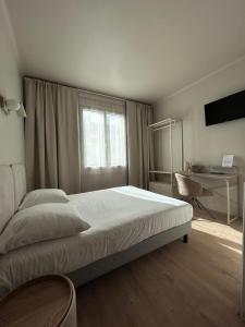 a bedroom with a bed and a window and a desk at Hotel Bloom in Caen
