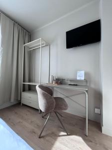 a desk with a mirror and a chair in a room at Hotel Bloom in Caen