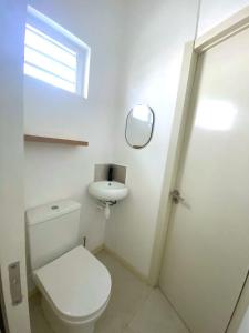 a white bathroom with a toilet and a sink at Nulacaz 2 - Centrally located in Rose Hill
