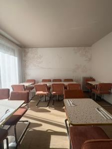 an empty room with desks and chairs in a classroom at Hotel Bloom in Caen