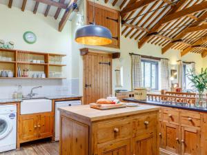 a kitchen with wooden cabinets and a black light fixture at 3 Bed in Fowey oc-55382 in Golant