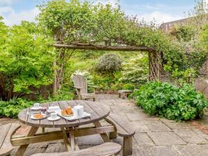a patio with a wooden table and chairs in a garden at 3 Bed in Fowey oc-55382 in Golant
