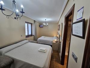 a hotel room with two beds and a tv at CASA RURAL BARAZAR in San Sebastián