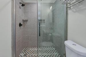 a shower with a glass door in a bathroom at Terlingua at the Bend in Wimberley
