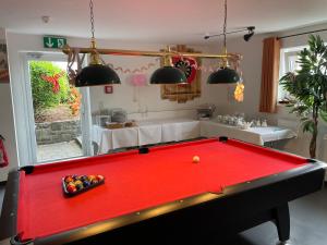 a red pool table in a living room at Phönix Hotel in Bergneustadt