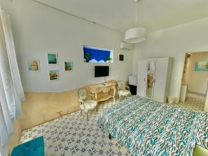 a bedroom with a bed and a desk and a television at B&B Villa Dunardi in Fontane Bianche