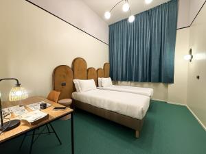 a room with two beds and a desk with a desk at QUO Milano in Milan +144 photos