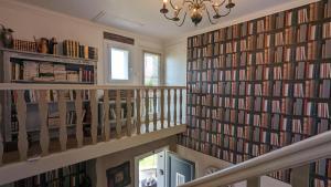 a library with a large wall of books at La Maison in Mirebeau-sur-Bèze