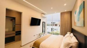 a bedroom with a bed and a tv and a window at Hotel Murahno Collection in Cúcuta