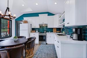 a kitchen with white cabinets and a table with chairs at Terlingua at the Bend in Wimberley +9 photos