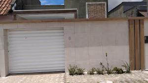 a white garage door on the side of a house at Acomodações em Bananeiras, PB in Bananeiras