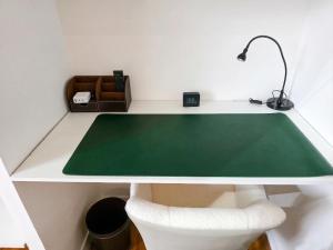 a white desk with a green rug and a chair at Maison Maubert in Thiers +8 photos