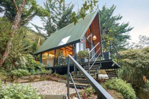 a small house with a green roof at Glamping en El Retiro in El Retiro +24 photos