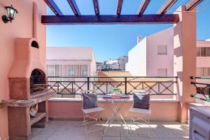 a balcony with a pizza oven and two chairs at Casa Essência in Armação de Pêra